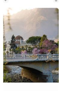 a bridge over a river with houses and trees at Portico 32 - Merano centro in Merano +17 photos