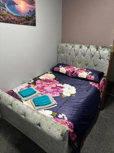 a bed in a room with a couch with flowers on it at Blackpool Beach Holiday Flats in Blackpool