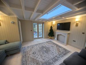 a living room with a television and a fireplace at Rose Cottage, Luxury cottage, sleeps 16 in South Raynham