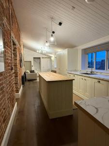 a kitchen with a counter and a brick wall at Rose Cottage, Luxury cottage, sleeps 16 in South Raynham