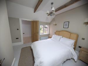 a bedroom with a white bed and a window at Rose Cottage, Luxury cottage, sleeps 16 in South Raynham