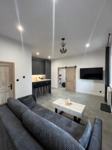 una sala de estar con un sofá y una mesa en Neighbourhood Apartment, en Lublin