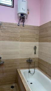 baño con bañera con una luz en la pared en Tranquil Retreat, en Māmandūr