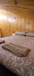 a bedroom with two beds and a wooden wall at Casa Umberna in Asiago