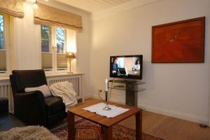 Una sala de estar con una silla y un televisor. en Min aran, en Oevenum