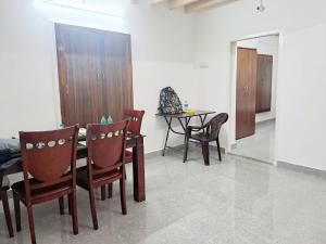 a dining room with a table and some chairs at Airport PickupBeachChepauk StadiumKitchenWIFI in Chennai