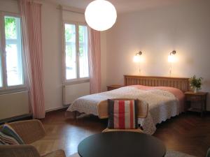 Un dormitorio con una cama y una mesa y dos ventanas. en Ferienhof Bühne, en Bühne
