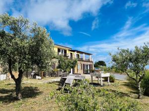 a house with a table and trees in front of it at Bella Vista Poggi 180Grad fantastischer Meerblick in Poggi