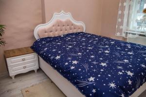 a bed with a blue comforter with stars on it at Zara Central Apartments in Arad