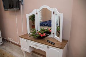 a table with a mirror and a bowl of fruit on it at Zara Central Apartments in Arad