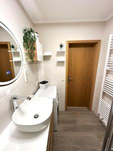 a bathroom with a white sink and a mirror at Ferienwohnung Käpt'n Pugs Kajüte auf Rügen in Göhren +23 photos
