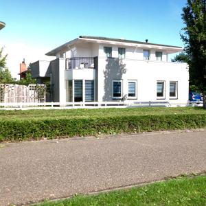 a white house on the side of a road at B&B Het Witte Huis in Almere