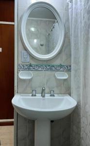 a bathroom with a white sink and a mirror at Hotel Carmen in San Bernardo