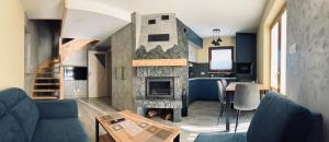a living room with a fireplace and a kitchen at Basikowe Wzgórze, 2 domki z kominkami i jacuzzi in Korbielów
