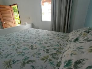 マラカジャウにあるCasa INTI de Maracajaúのベッドルーム1室(花柄のベッドカバー付)