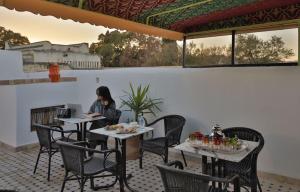a woman sitting at a table on a patio at Dar Mima in Fez