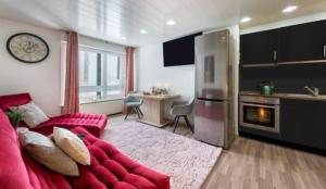 uma sala de estar com um sofá vermelho e uma cozinha em Apartment Kandahar 42 em Crans-Montana