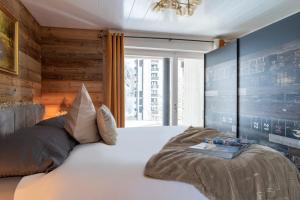 um quarto com uma grande cama branca e uma janela em Apartment Kandahar 42 em Crans-Montana