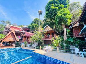 a resort with a swimming pool and some buildings at Golden Hill Guesthouse in Phi Phi Islands
