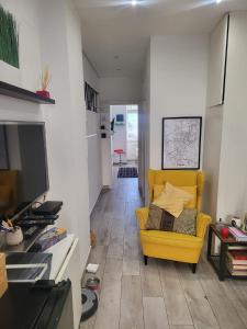 a living room with a yellow couch and a television at Casa Vacanze Panoramica in Bagnoli del Trigno