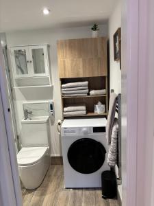 a bathroom with a washing machine and a toilet at Loom Lodge in Great Wyrley +10 photos
