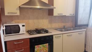 a kitchen with a microwave and a stove and a sink at Casa David in Cava deʼ Tirreni +3 photos