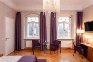 a bedroom with a bed and a table and chairs at Hotel Schloss Rabenstein in Chemnitz