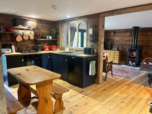 a kitchen with black cabinets and a wooden floor at Moonshine in Grimston