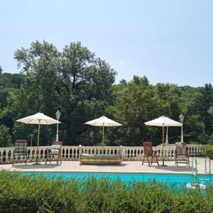 a group of chairs and umbrellas next to a pool at La manufacture royale de la bonde Chambre 1 in Cuxac-Cabardès