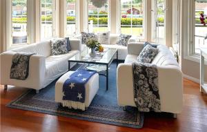 a living room with white couches and a table at Amazing Home In Strömstad With Sauna in Lökholmen