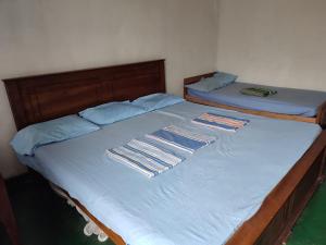 zwei Einzelbetten in einem Zimmer mit blauer Bettwäsche in der Unterkunft Subhasinghe guest in Ella