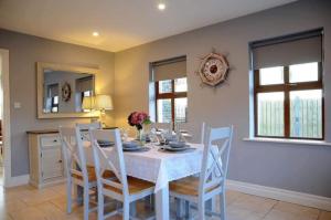 a dining room with a white table and chairs at Holiday Home Dingle in Dingle