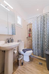 a bathroom with a sink and a toilet and a shower at Tommys Apartment in Nei Poroi +42 photos