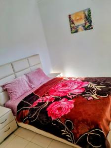 a bedroom with a bed with a red and black blanket at Marwan's apartment 2 in Ifrane