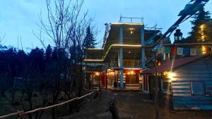 a building with lights on the side of it at night at Basecamp Manali in Manāli