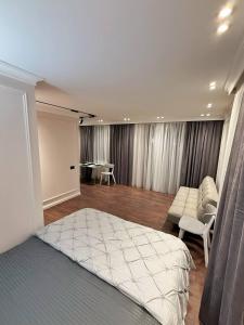 a bedroom with a bed and a chair and a desk at Ultra Central Apartment in Chișinău in Chişinău