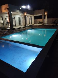 a swimming pool lit up at night at Luxury Private Villa with Pool in The Gambia in Sambuya