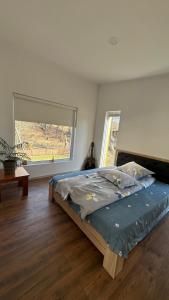 una cama en una habitación con una ventana grande en Oaza de liniște Olănești, en Valea Cheii