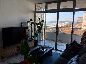 a living room with a flat screen tv and a large window at 10 South Ocean Views in Durban