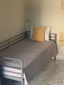 a bed with an orange pillow on top of it at POSIDONIA RESORT No7 in Nea Vrasna