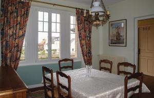 a dining room with a table and chairs and a window at Holiday Home Hent Gwaz Ar Gouez in Locquémeau