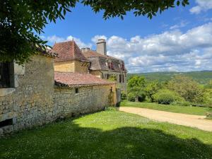 un vecchio edificio in pietra con un sentiero di fronte di La Ferme de Belbouys a Soturac