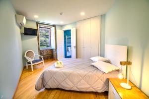 a bedroom with a bed and a desk and a chair at Fândega House - Rural Tourism in Loriga +39 photos