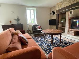 un soggiorno con un divano e un tavolo di La Ferme de Belbouys a Soturac