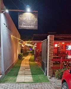 un edificio con un letrero para un restaurante por la noche en Pousada Gostoso Village, en São Miguel do Gostoso
