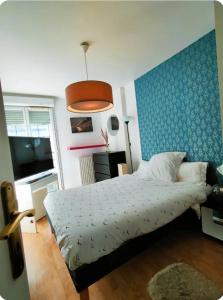 a bedroom with a bed and a blue wall at Spacieux, moderne et familiale - Paris à porte - Au pied du métro 14 in Clichy +8 photos