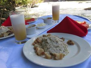 a table with a white plate of food and drinks at Casa Kwalama in Santa Marta