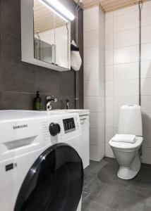 a bathroom with a washing machine and a toilet at Arctic Honey City Suite in Rovaniemi