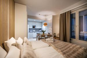 a bedroom with a white bed and a kitchen at Arctic Honey City Suite in Rovaniemi
