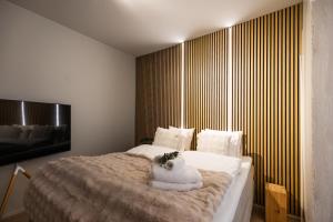 a bedroom with a large bed with white sheets at Arctic Honey City Suite in Rovaniemi